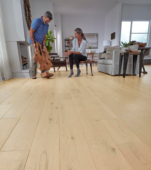 A man and woman select organic wood decor to accent their Mohawk hardwood floors in a natural blonde wood tone.